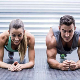 Portrait of a muscular couple doing planking exercises